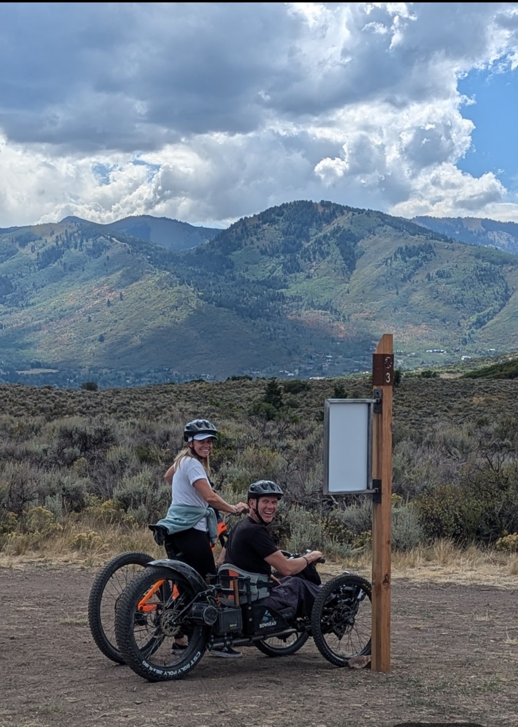 Adaptive cyclists on the trail with mountain views
