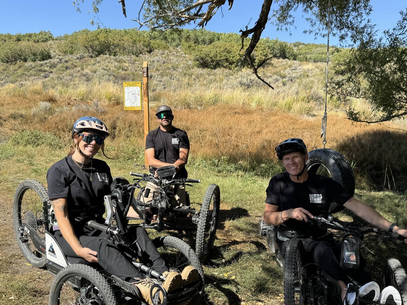 Three people on adaptive bikes